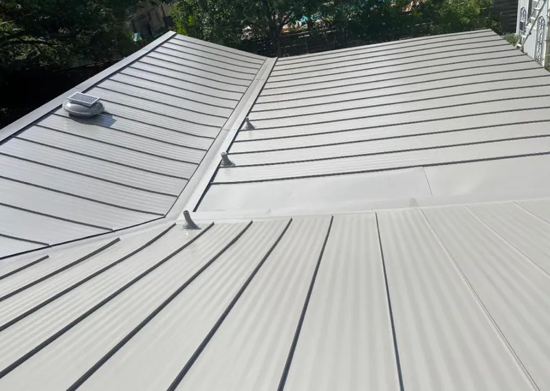 Solar attic fan installed on a metal roof for Roof Ventilation in Media